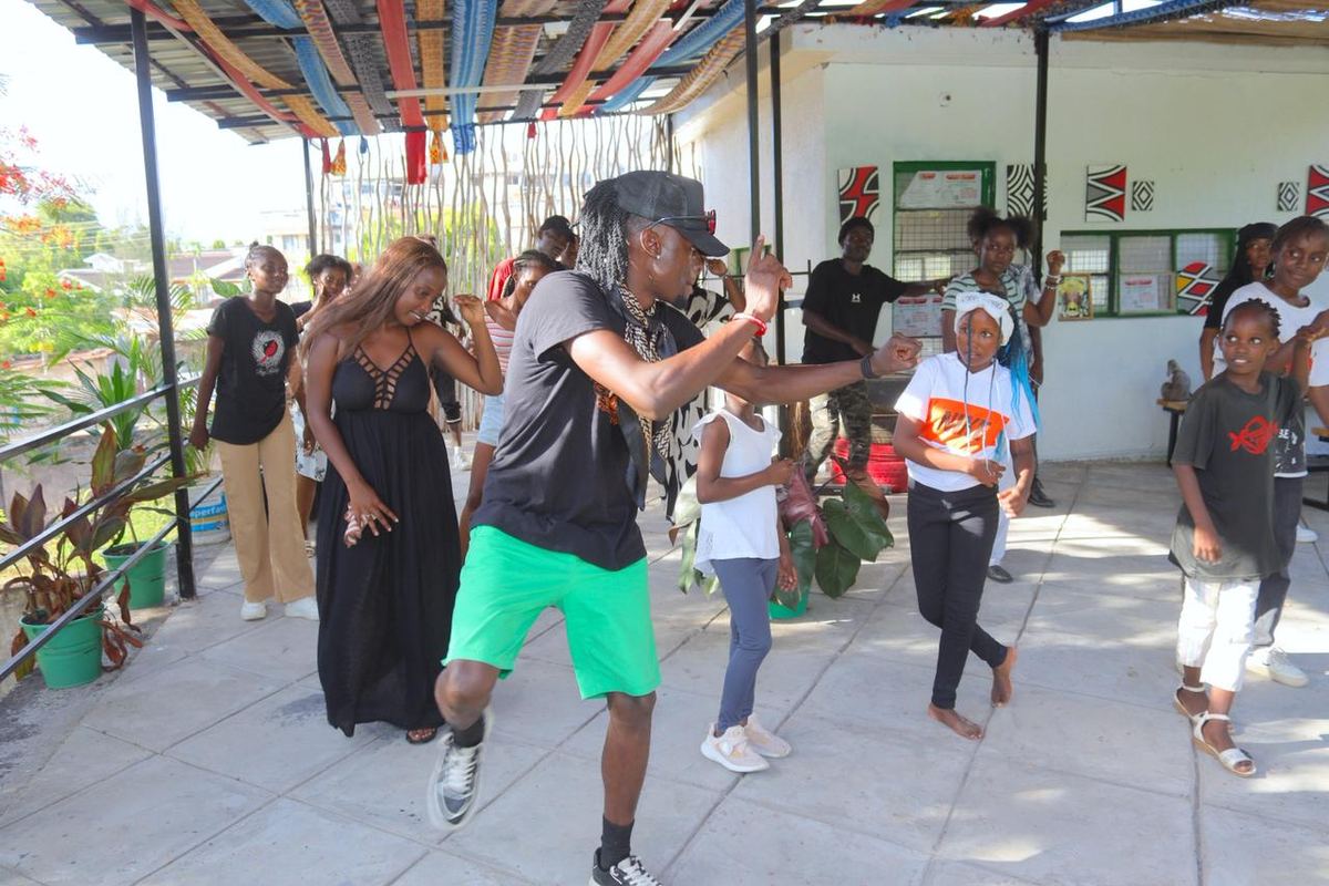 Adults and children dancing together on the terrace at Africa Nomads Art Space.