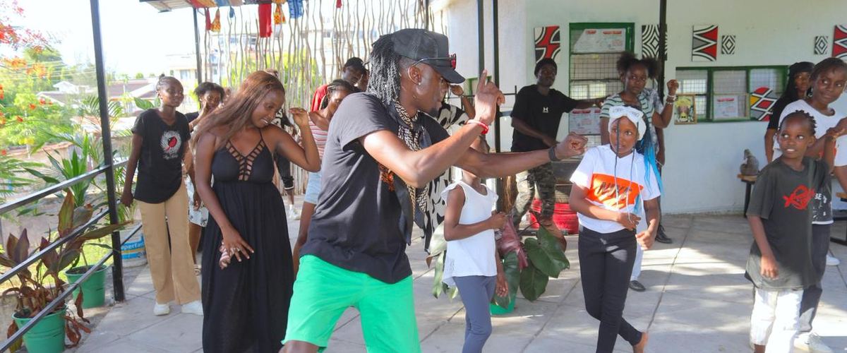 A dance session on the open terrace at Africa Nomads Art Space, with adults and children following a lead dancer.